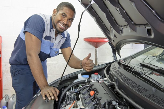 Mechanic looking under hood of car